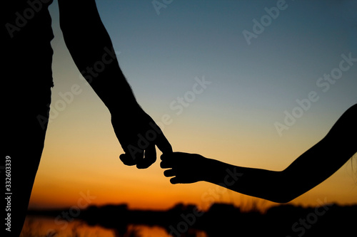 silhouette the parent holds the hand of a child © Kostia