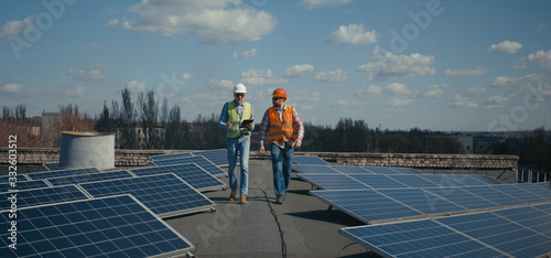 Engineer and technician discussing between solar panels photo