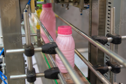 Plastic milk bottles on the conveyor on a modern dairy plant. Food industry