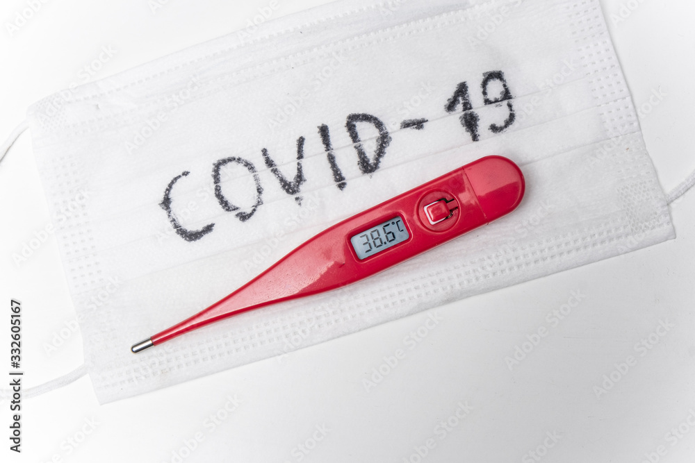 Thermometer on the surgical mask. High temperature as a main symptom of virus infection. Covid-19. Thermometer on the surgical mask. High temperature as a main symptom of virus infection. Covid-19.