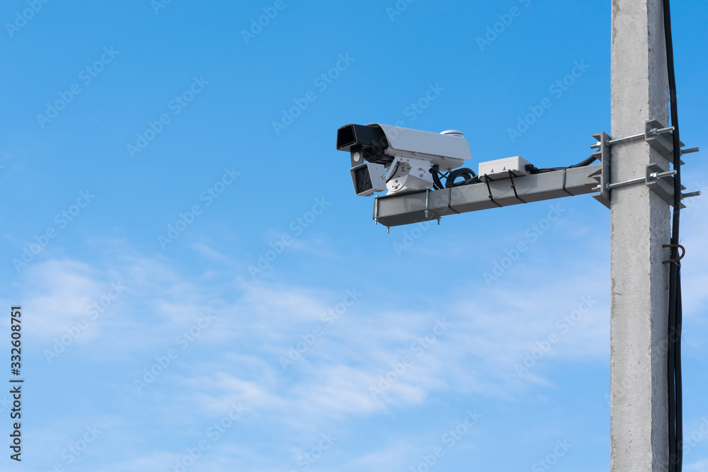 Speed camera. Blue sky background, concrete support.