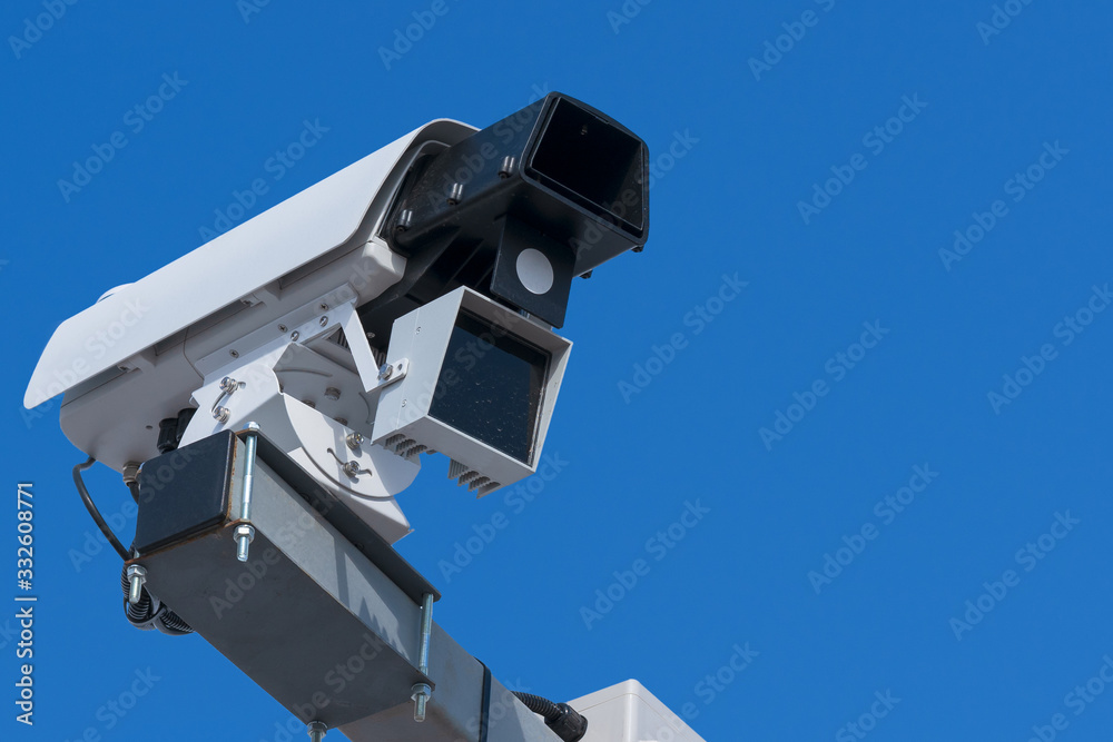 Speed camera. Close-up with details, blue sky background. Speed camera. Close-up with details, blue sky background.