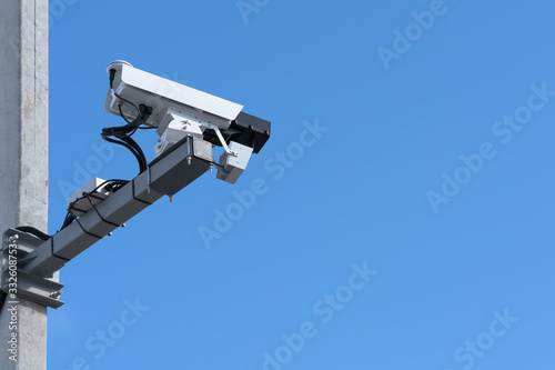 Speed camera. Blue sky background, concrete support, bottom view.
