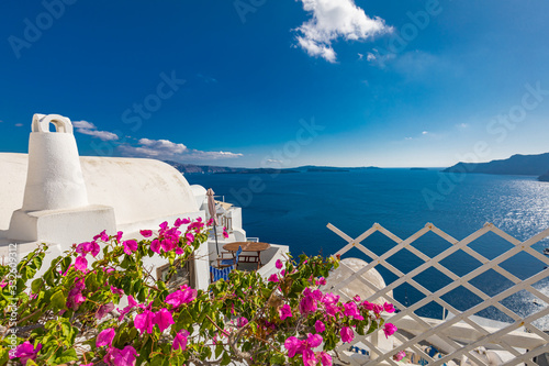 Wonderful scenery, summer travel landscape, vacation background. Flowers on the terrace. Beautiful landscape with sea view. White architecture on Santorini island, Greece.