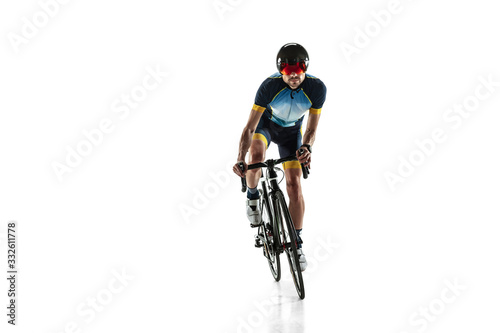 Triathlon male athlete cycle training isolated on white studio background. Caucasian fit triathlete practicing in cycling wearing sports equipment. Concept of healthy lifestyle, sport, action, motion.