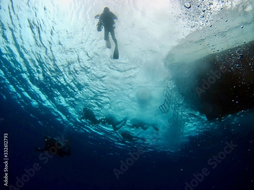 船から飛び込んで泳ぎ始める数名のダイバー © Hiroko