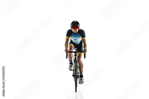 Triathlon male athlete cycle training isolated on white studio background. Caucasian fit triathlete practicing in cycling wearing sports equipment. Concept of healthy lifestyle, sport, action, motion.