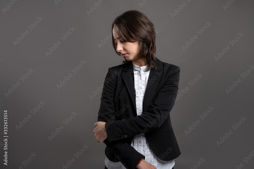 Portrait of wonderful young business woman elbow pain poseing on isolated gray background Portrait of wonderful young business woman elbow pain poseing on isolated gray background