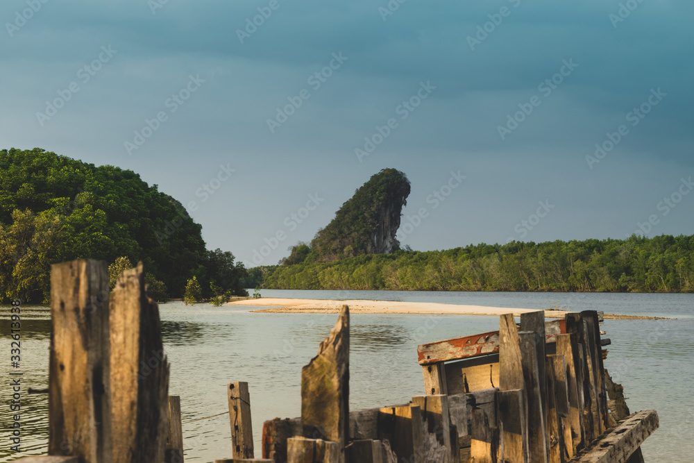 Abandoned boat and Khao Khanab Nam mountains in Krabi town