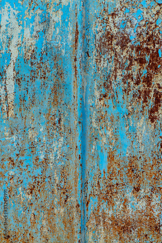 rust and damaged blue and yellow paint on metal sheet