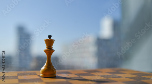 old chess pieces on a chessboard against a blue sky