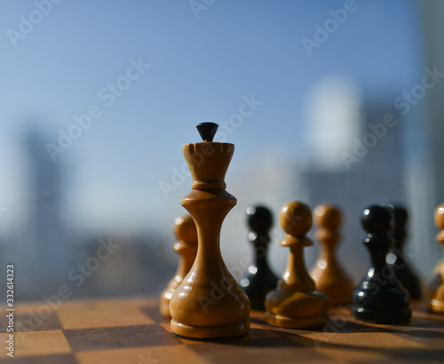 old chess pieces on a chessboard against a blue sky