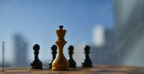 old chess pieces on a chessboard against a blue sky