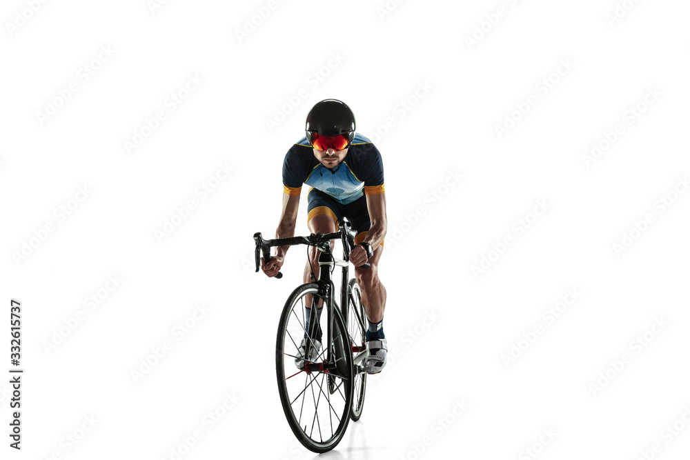Obraz premium Triathlon male athlete cycle training isolated on white studio background. Caucasian fit triathlete practicing in cycling wearing sports equipment. Concept of healthy lifestyle, sport, action, motion.