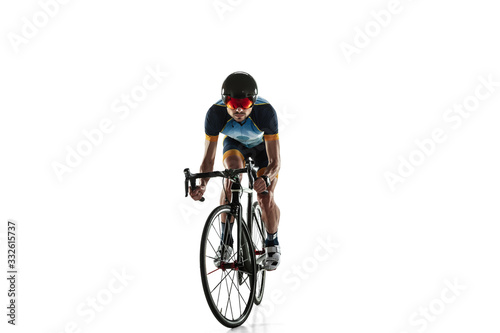 Triathlon male athlete cycle training isolated on white studio background. Caucasian fit triathlete practicing in cycling wearing sports equipment. Concept of healthy lifestyle, sport, action, motion.