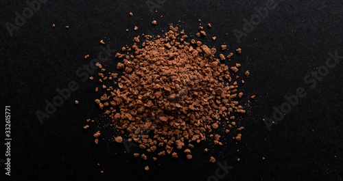 Pile of cocoa powder on black background, top view