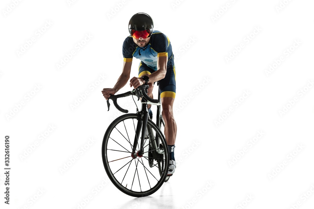 Triathlon male athlete cycle training isolated on white studio background. Caucasian fit triathlete practicing in cycling wearing sports equipment. Concept of healthy lifestyle, sport, action, motion. Triathlon male athlete cycle training isolated on white studio background. Caucasian fit triathlete practicing in cycling wearing sports equipment. Concept of healthy lifestyle, sport, action, motion.