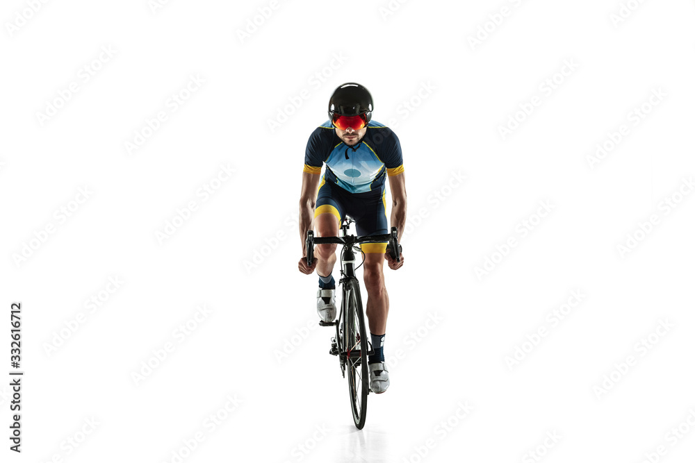 Fototapeta premium Triathlon male athlete cycle training isolated on white studio background. Caucasian fit triathlete practicing in cycling wearing sports equipment. Concept of healthy lifestyle, sport, action, motion.