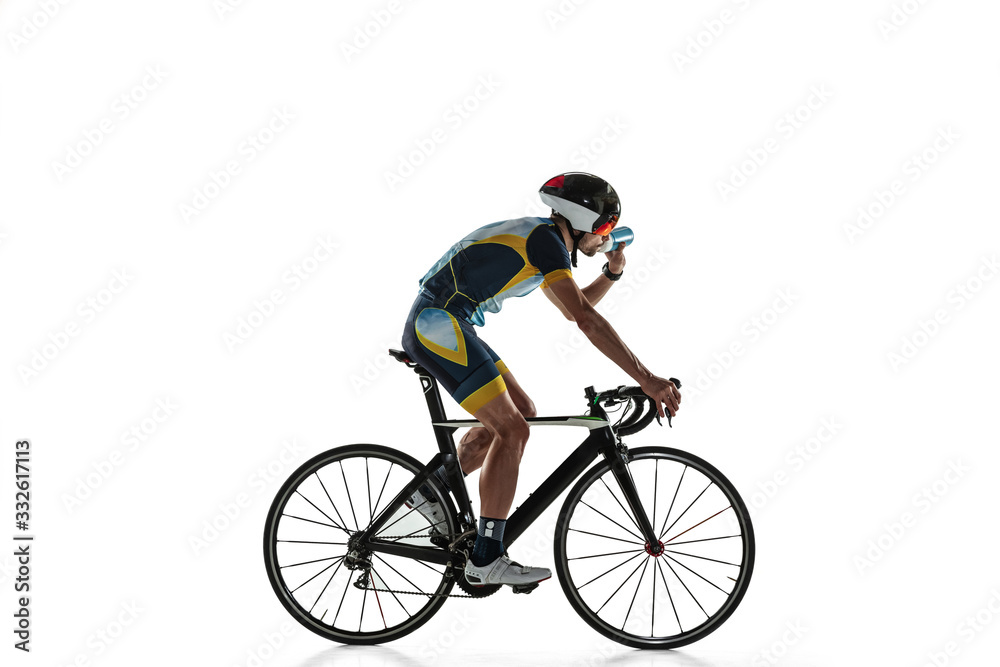 Triathlon male athlete cycle training isolated on white studio background. Caucasian fit triathlete practicing in cycling wearing sports equipment. Concept of healthy lifestyle, sport, action, motion. Triathlon male athlete cycle training isolated on white studio background. Caucasian fit triathlete practicing in cycling wearing sports equipment. Concept of healthy lifestyle, sport, action, motion.