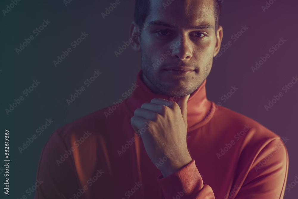 Studio close-up portrait of attractive male model. Color flash studio light Studio close-up portrait of attractive male model. Color flash studio light