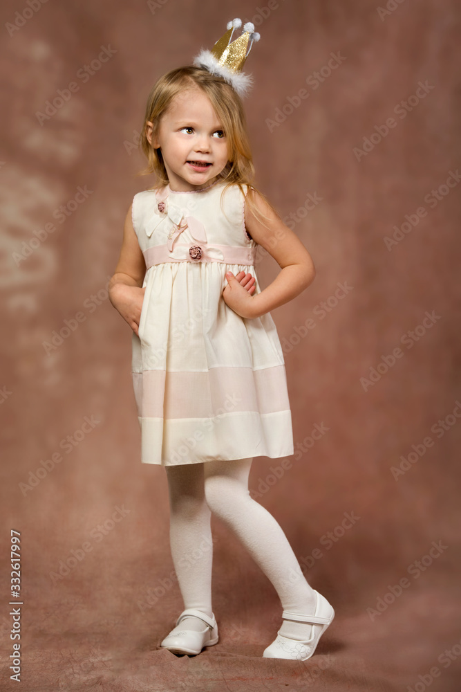 Cheerful little girl with long blond hair in in princess dress and crown Cheerful little girl with long blond hair in in princess dress and crown