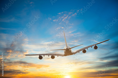Passengers commercial airplane flying in sunset © Jag_cz