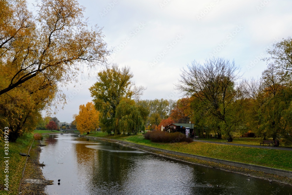 Pond with ducks and colorful trees in the park on a warm autumn day. Kepa Potocka, Warsaw, Poland Pond with ducks and colorful trees in the park on a warm autumn day. Kepa Potocka, Warsaw, Poland