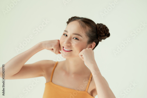 Portrait of nice cute positive pretty girl with two buns isolated on light background