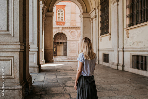 A beautiful woman with blond hair walks through the streets of the city. Girl enjoy holidays in Europe. Beautiful historical architecture. Italian weekend. Travel to Turin, Italy. Adventure lifestyle