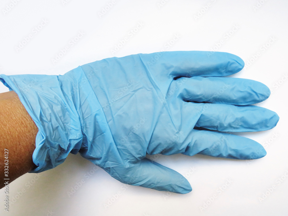 Horizontal overhead view of durable, blue disposable surgical latex glove isolated on white background. Protection against harmful substances, viruses and food handling. Horizontal overhead view of durable, blue disposable surgical latex glove isolated on white background. Protection against harmful substances, viruses and food handling.