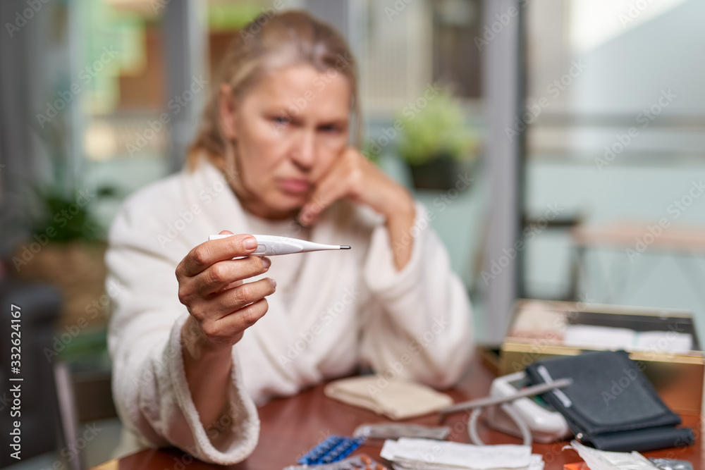 Sickness, seasonal virus problem concept. Senior woman being sick having flu at temperature on thermometer. Sickness, seasonal virus problem concept. Senior woman being sick having flu at temperature on thermometer.