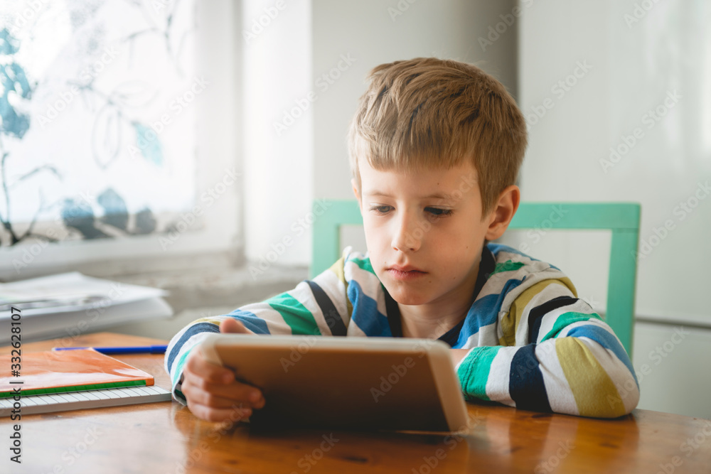 Young Boy looking at digital tablet, staying at home Young Boy looking at digital tablet, staying at home