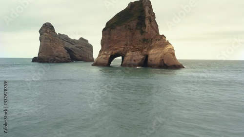 Famous rock formations on the Wharariki beach, popular tourist destination in South Island New Zealand photo