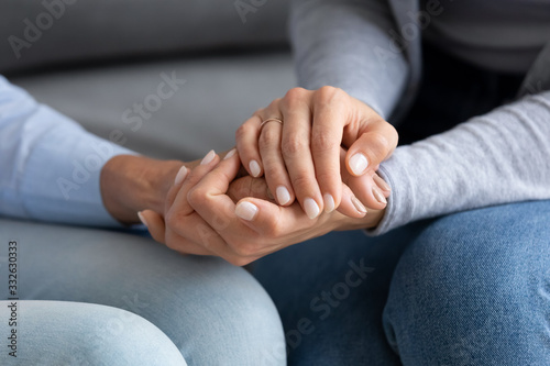 Close up of millennial girl hold hands share close intimate moment with elderly mom at home  mature mother and grown-up adult daughter show care and support enjoy time together  bonding concept