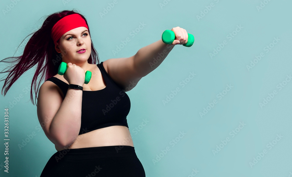 Fitness spring diet weight loss concept. Active plus-size overweight woman does exercises with weights dumbbells punches - obrazy, fototapety, plakaty 