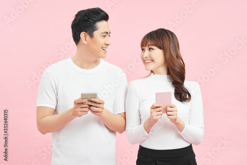 Image of asian man and woman using smartphones isolated over colorful background photo