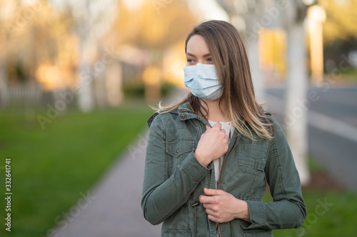 On the street, a girl in a place, protected from coronavirus. A virus outbreak, danger, and quarantine. Photo for news and media