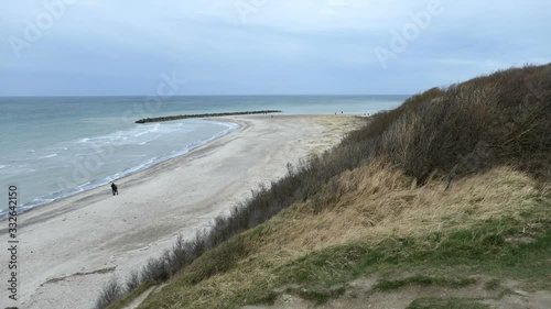 Aerial view from coast cliff of Ahrenshoop Baltic sea down to beach. People walking along.