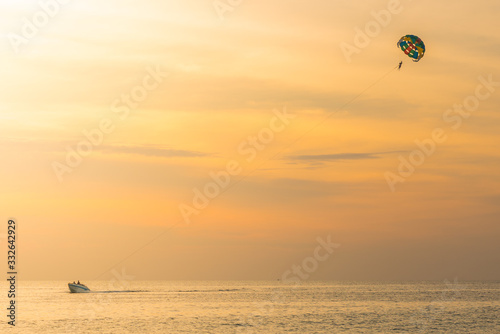 Tourists para-sailing in sunset time at Phuket Beach, Thailand