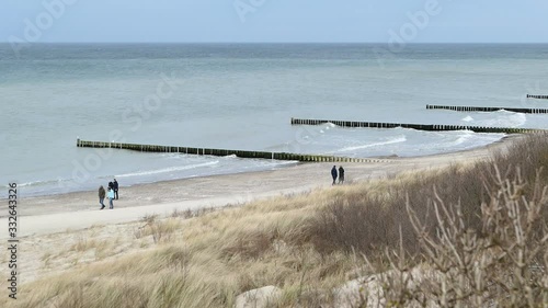 Aerial view from coast cliff of Ahrenshoop Baltic sea down to beach. People walking along.