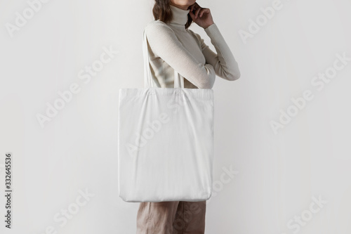 Urban mockup of tote bag. Girl holding white cotton tote bag 