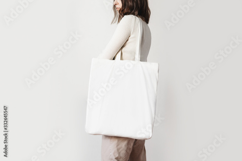 Urban mockup of tote bag. Girl holding white cotton tote bag 