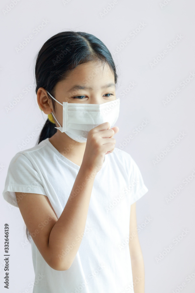 Portrait of Asian little girl wearing a protective medical mask and coughs