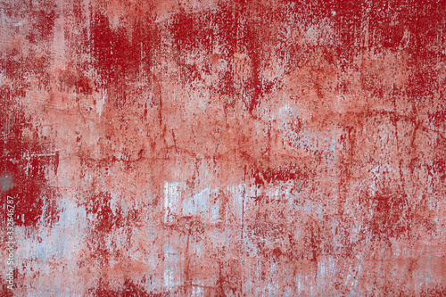 Background texture of an old concrete wall with peeling red paint