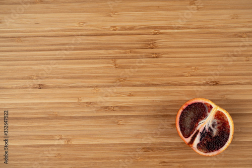 Fototapeta Naklejka Na Ścianę i Meble -  Bloody orange on a wooden surface top view close-up
