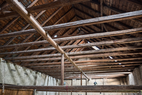 Aged beams in an old barn. Old roof achitecture detail. Wooden timbers.