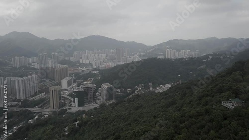 Flying over Hong Kong village, with buildings and mountain trees