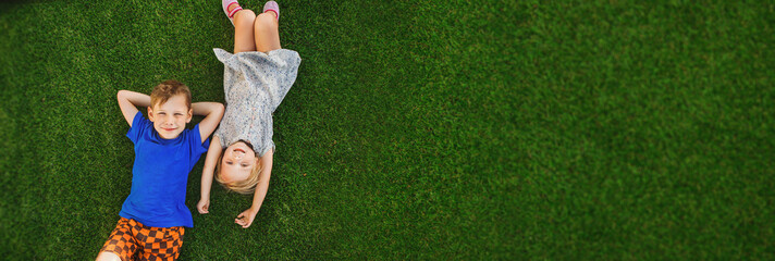 children lying on the green grass in the Park. The interaction of the children