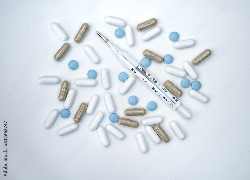 pills and thermometer isolated on white background pills and thermometer isolated on white background