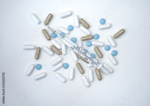pills and thermometer isolated on white background